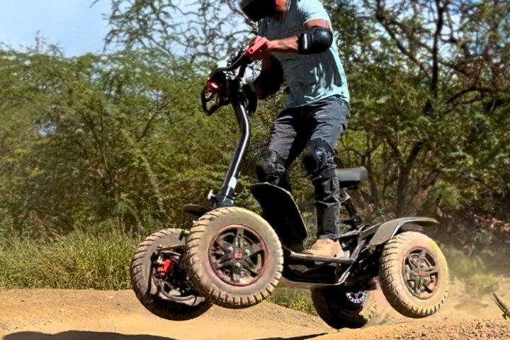 a man riding a motorcycle down a dirt road