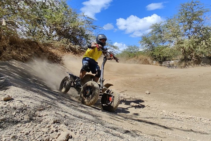 a man riding a motorcycle down a dirt road